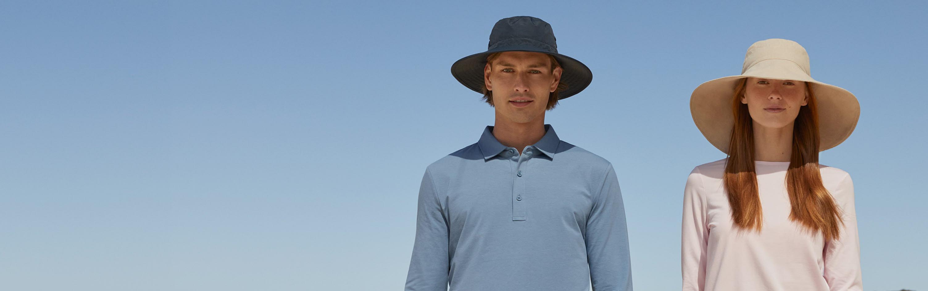 Two people wearing hats against a clear blue sky