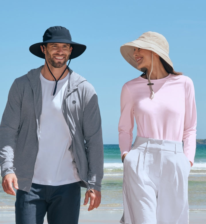 Man and woman wearing Solbari wide-brimmed hats on a beach