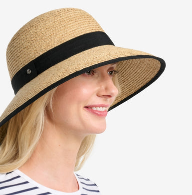 Woman wearing a straw hat with a black band on a white background